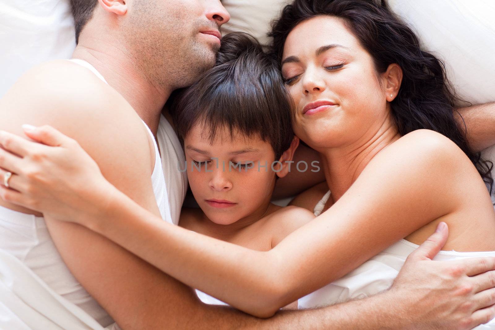 Portrait of a young family sleeping in bed 