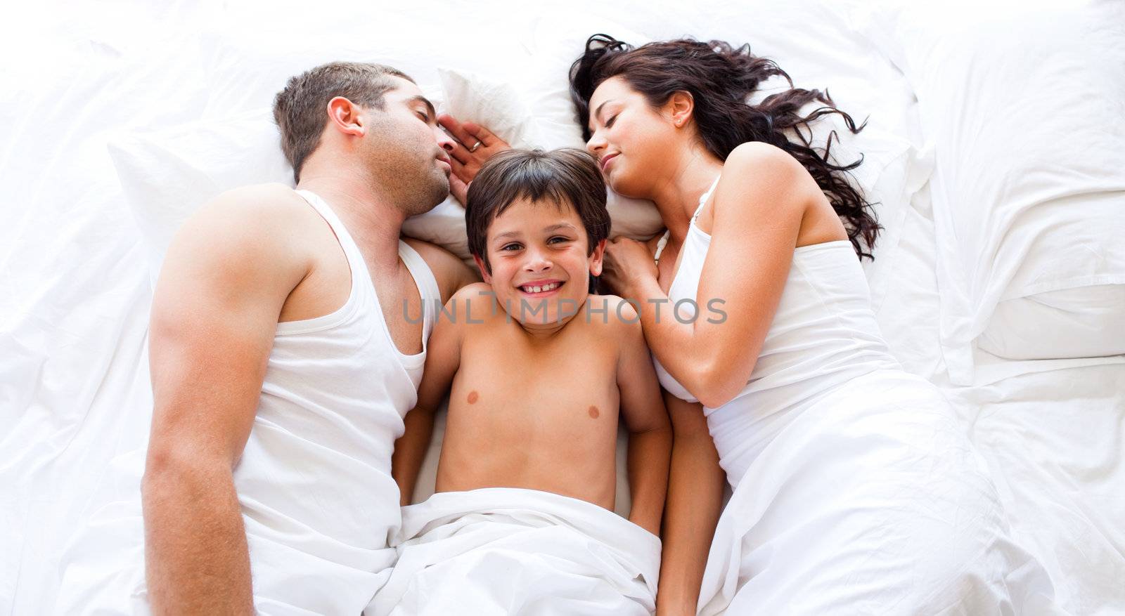 Smiling son with his parents sleeping by Wavebreakmedia