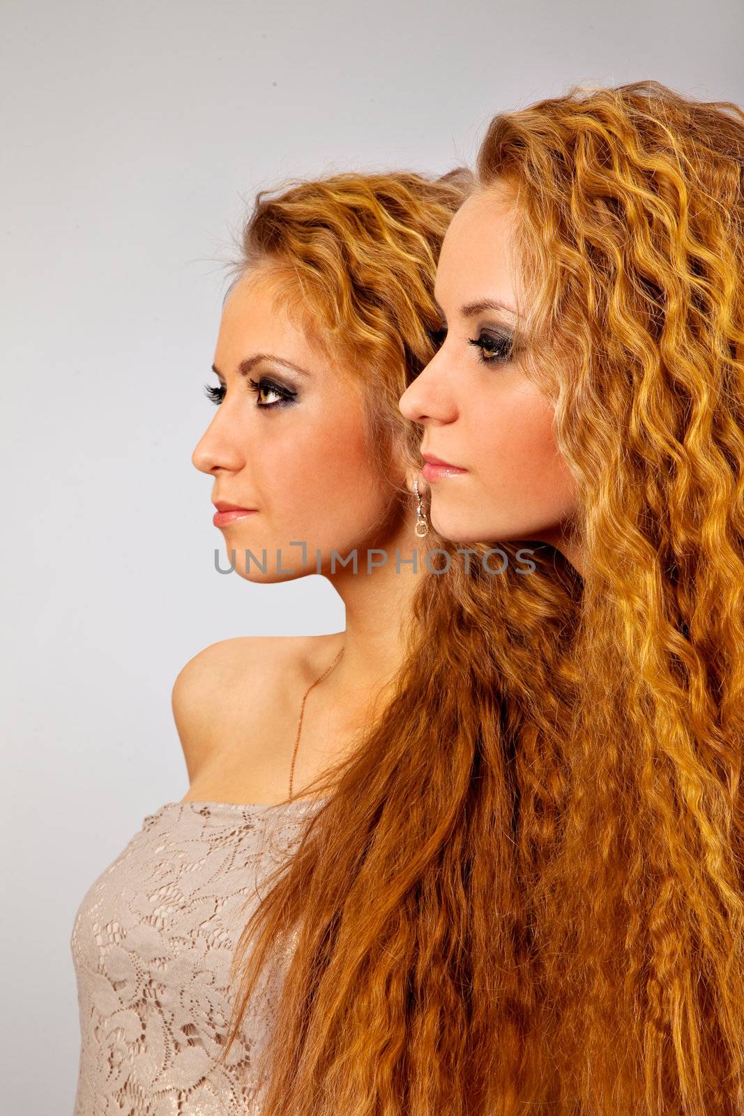 Sttudio shot portrait on isolated background of two sisters twin women friends