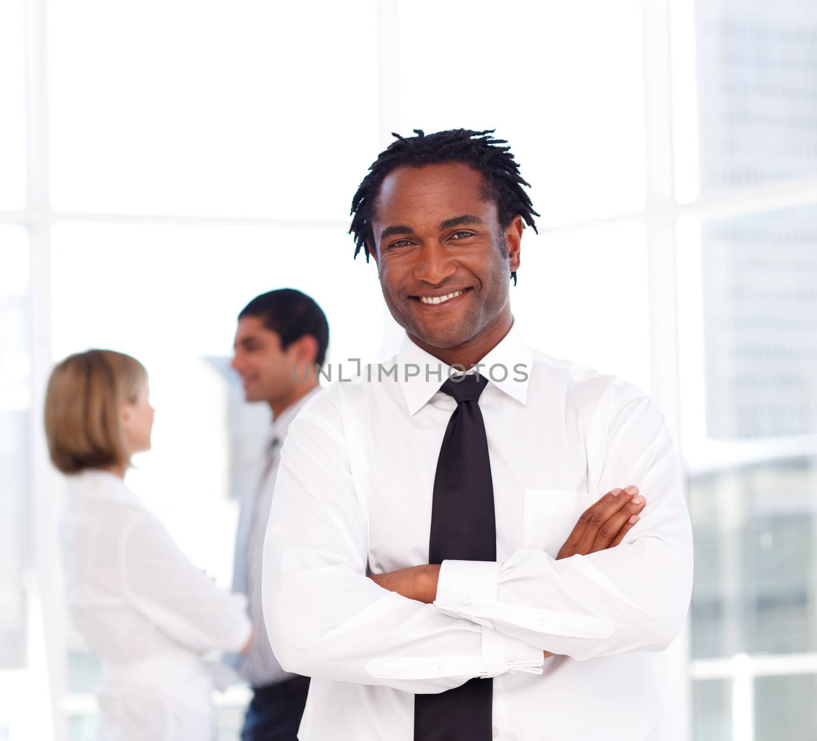 Young African businessman with folded arms smiling at the camera