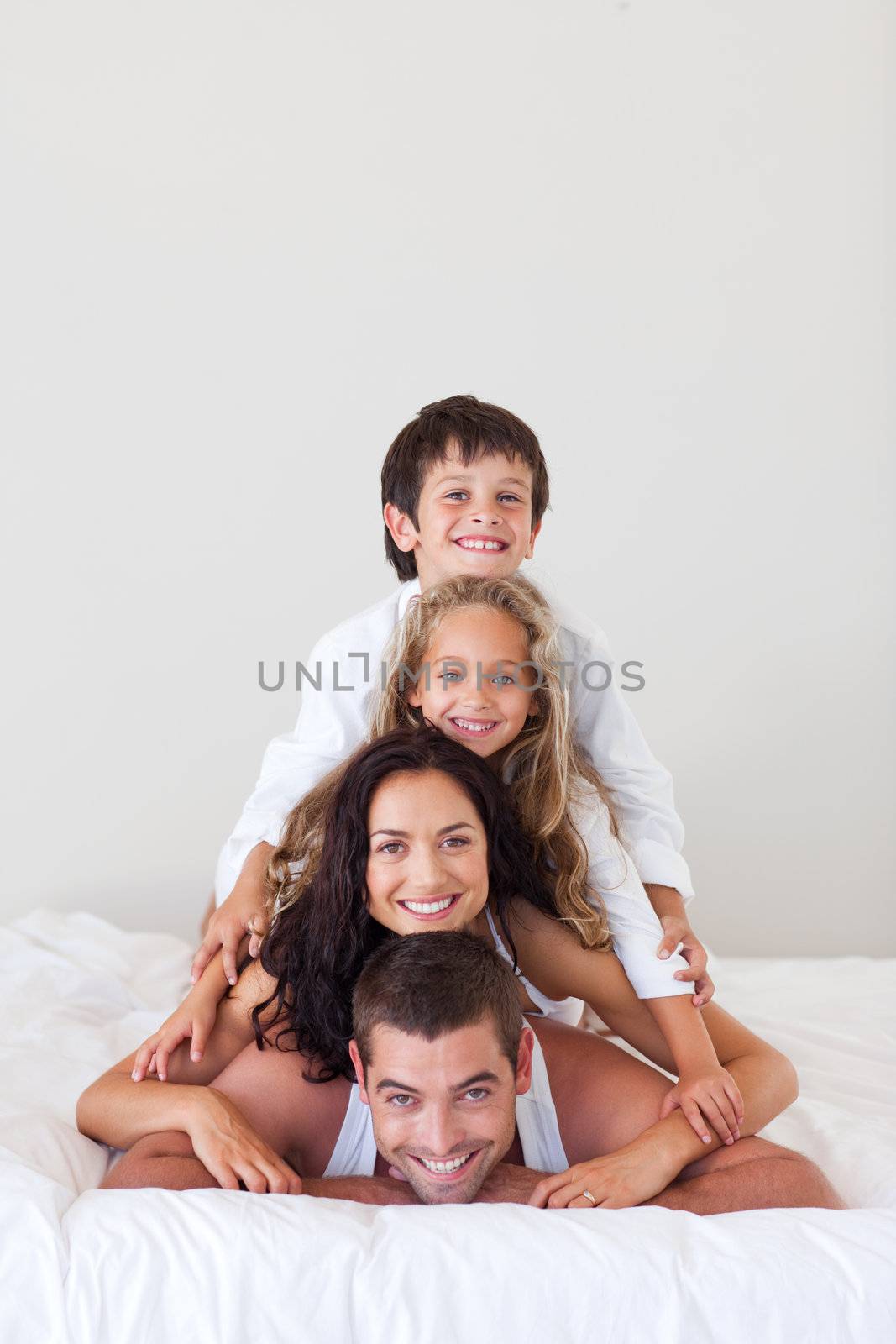 Smiling family lying on their bed