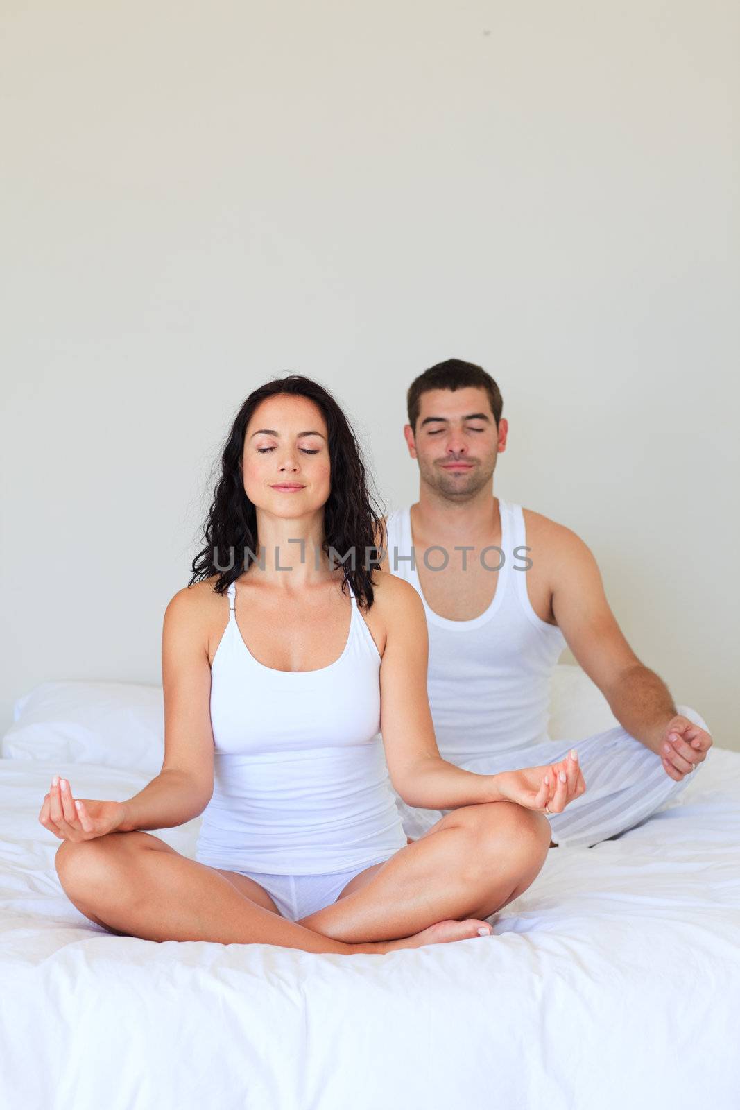 Couple meditating in bed by Wavebreakmedia