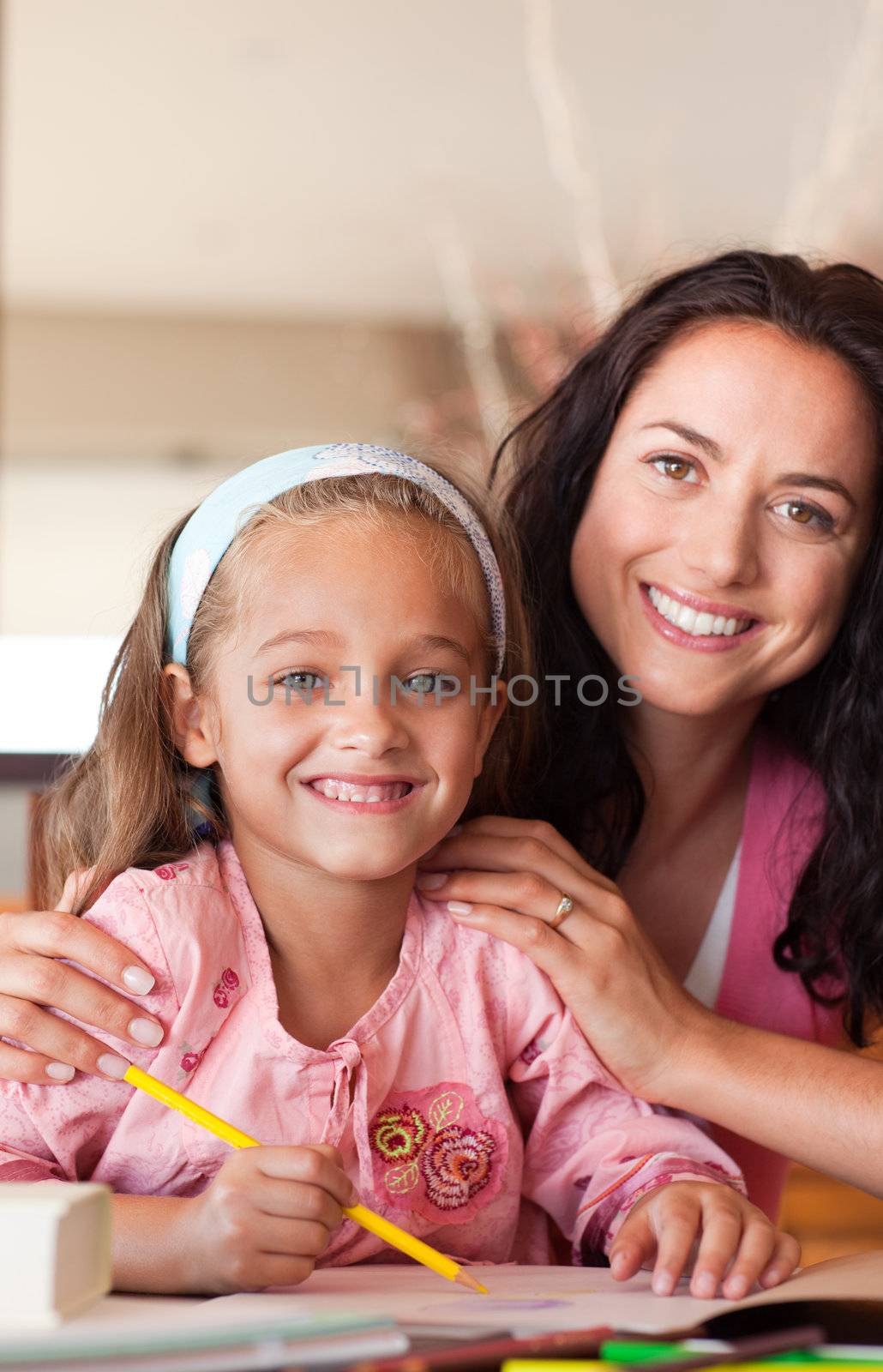 Smiling mother helping her son for homework