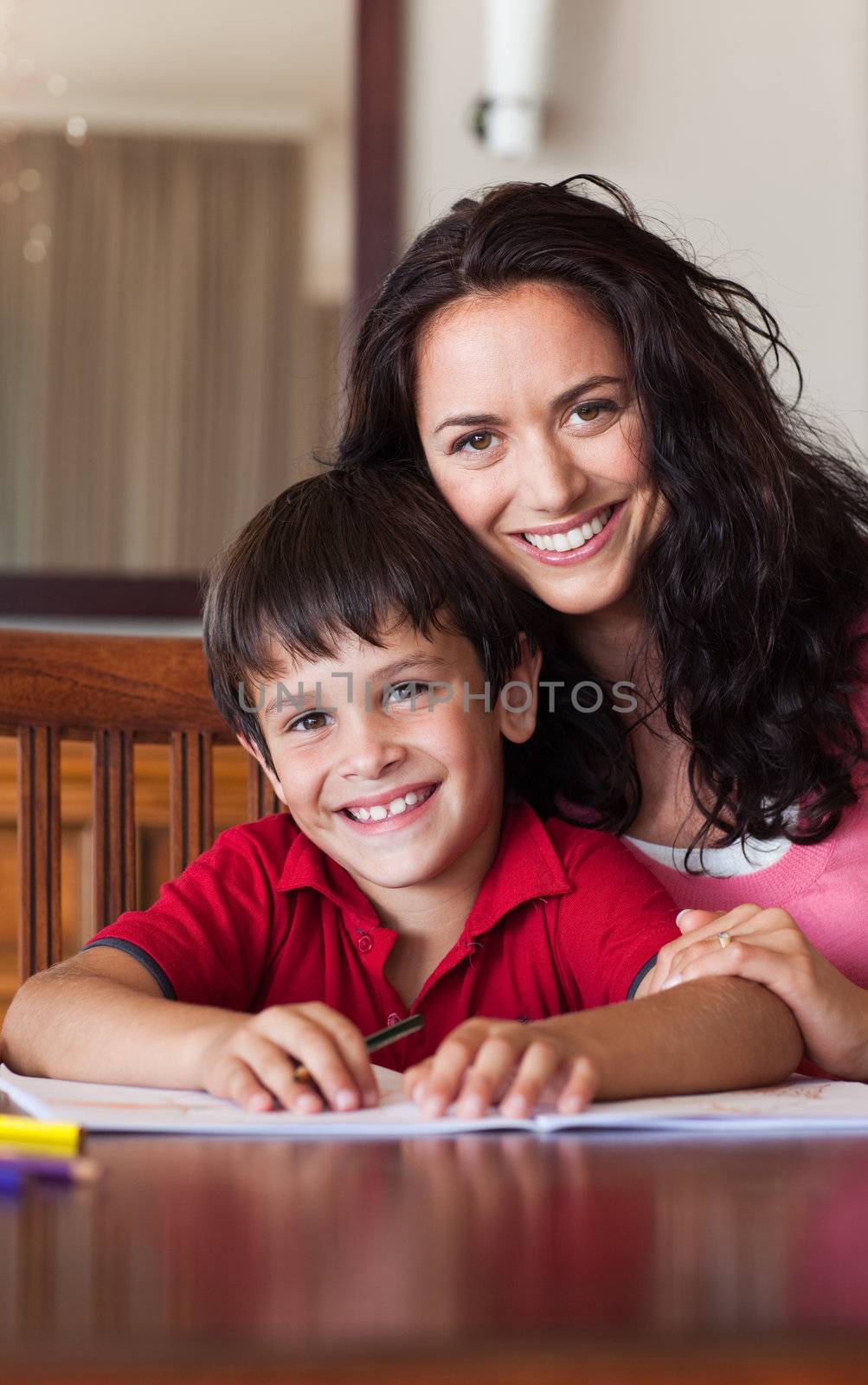 Delighted mother helping his son for homework