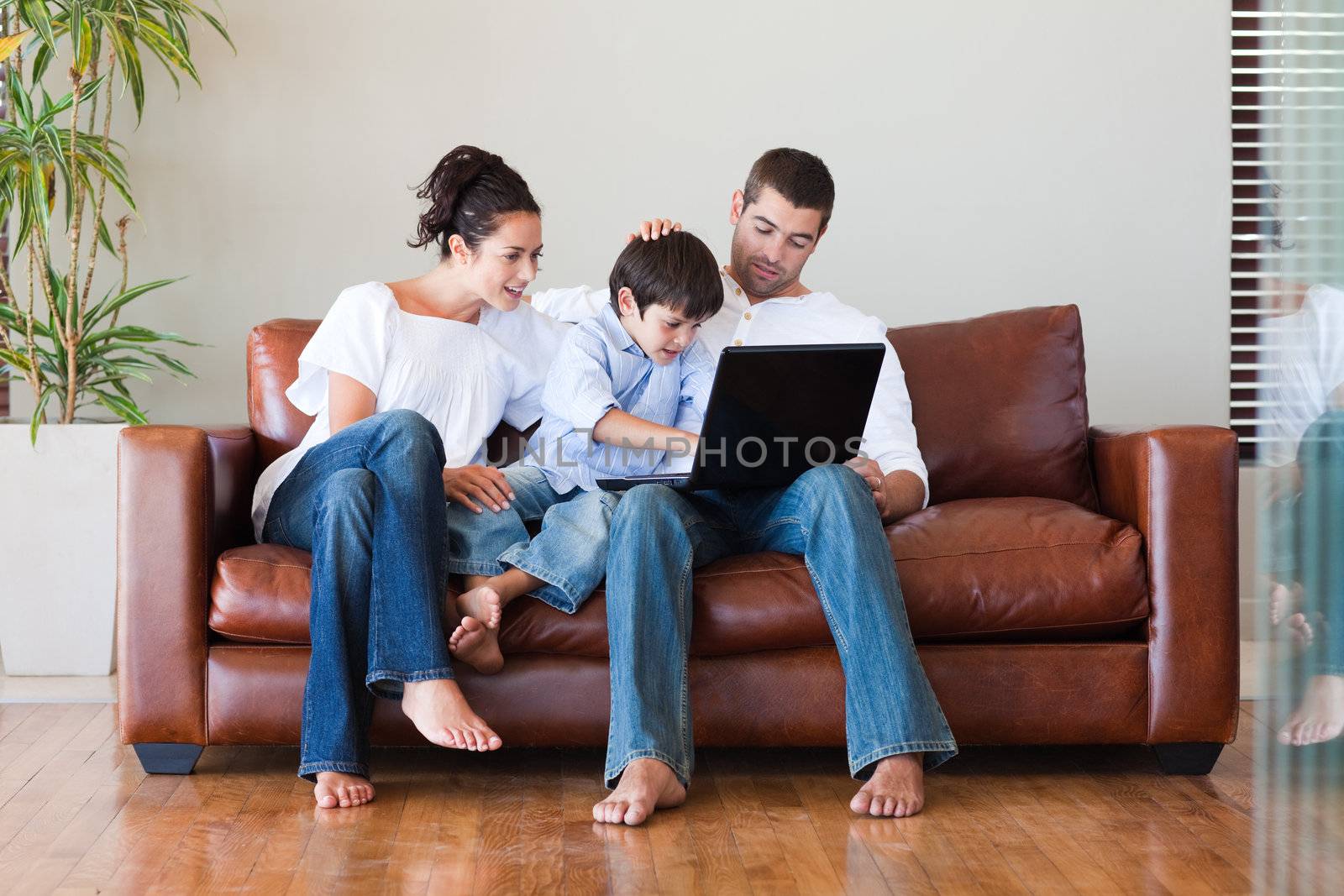 Parents and son playing with a laptop by Wavebreakmedia