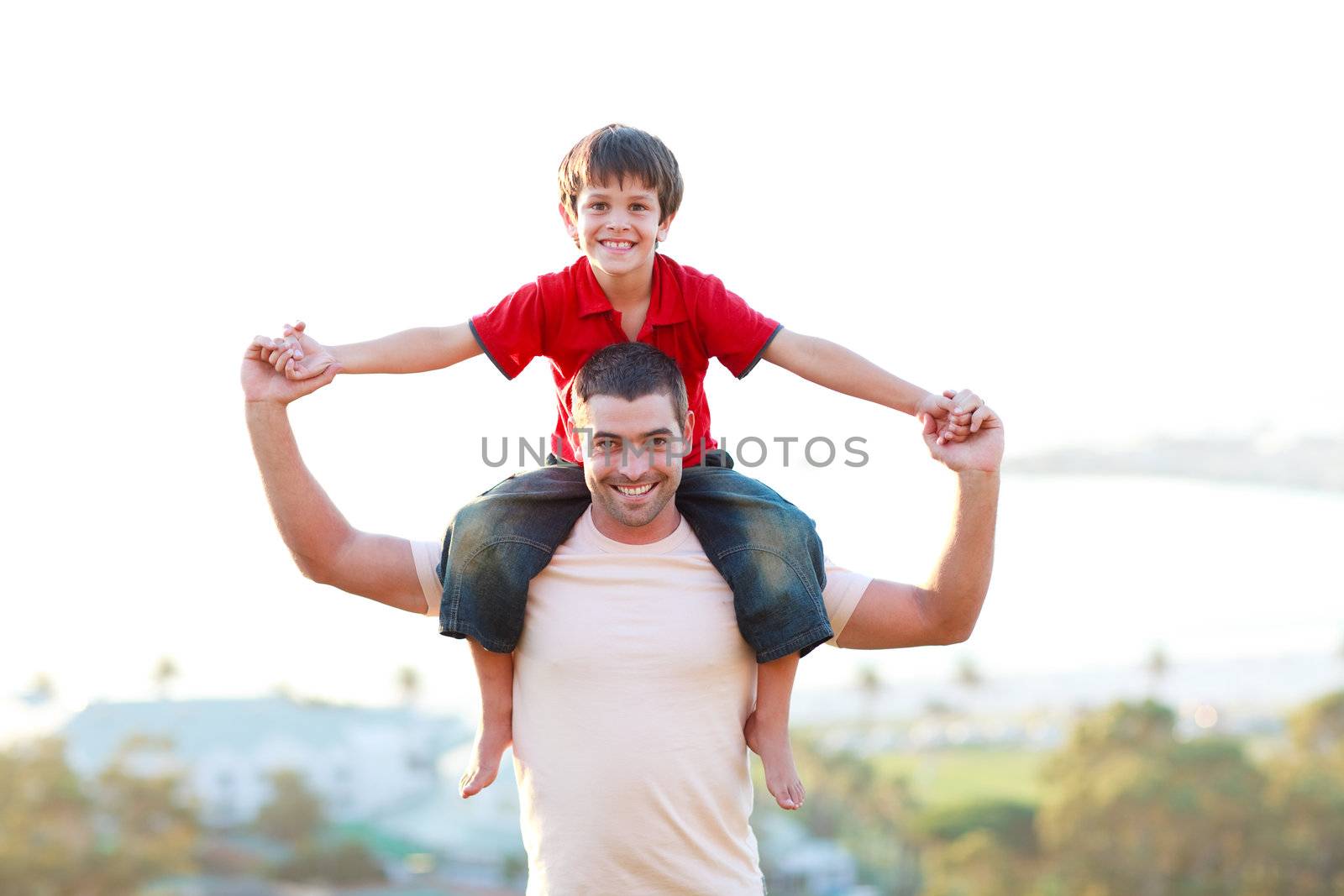 Father giving son piggyback ride by Wavebreakmedia