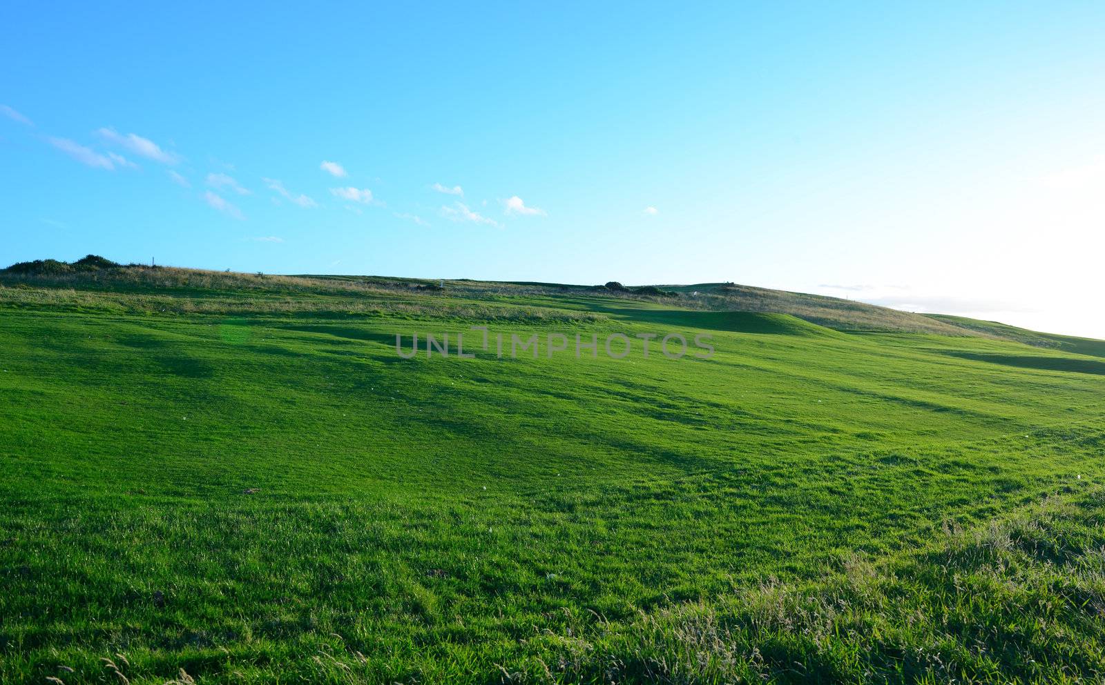 The very nice golf course fairway with blue sky background.
