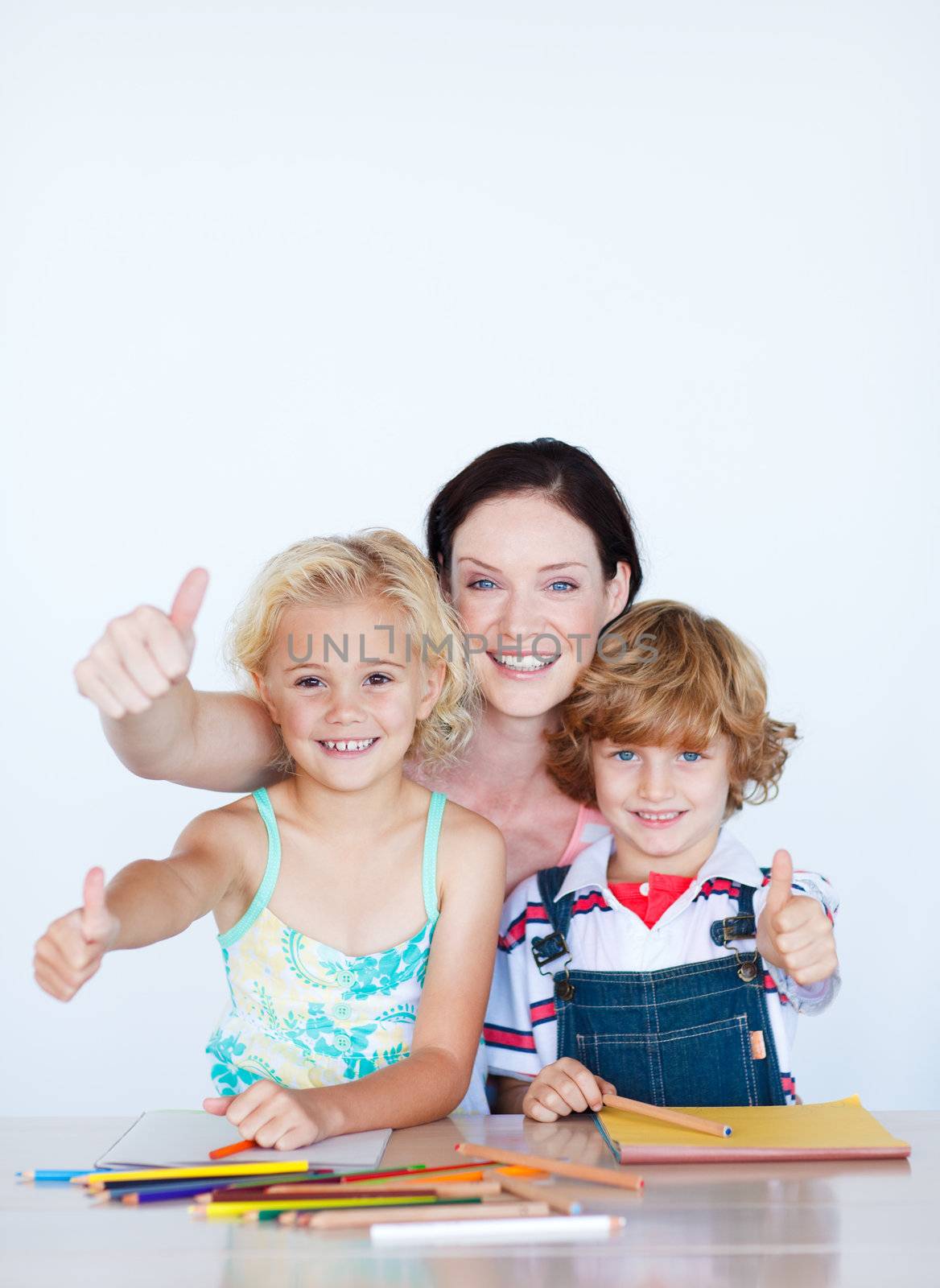 Happy children doing homework with their mother with copy-space