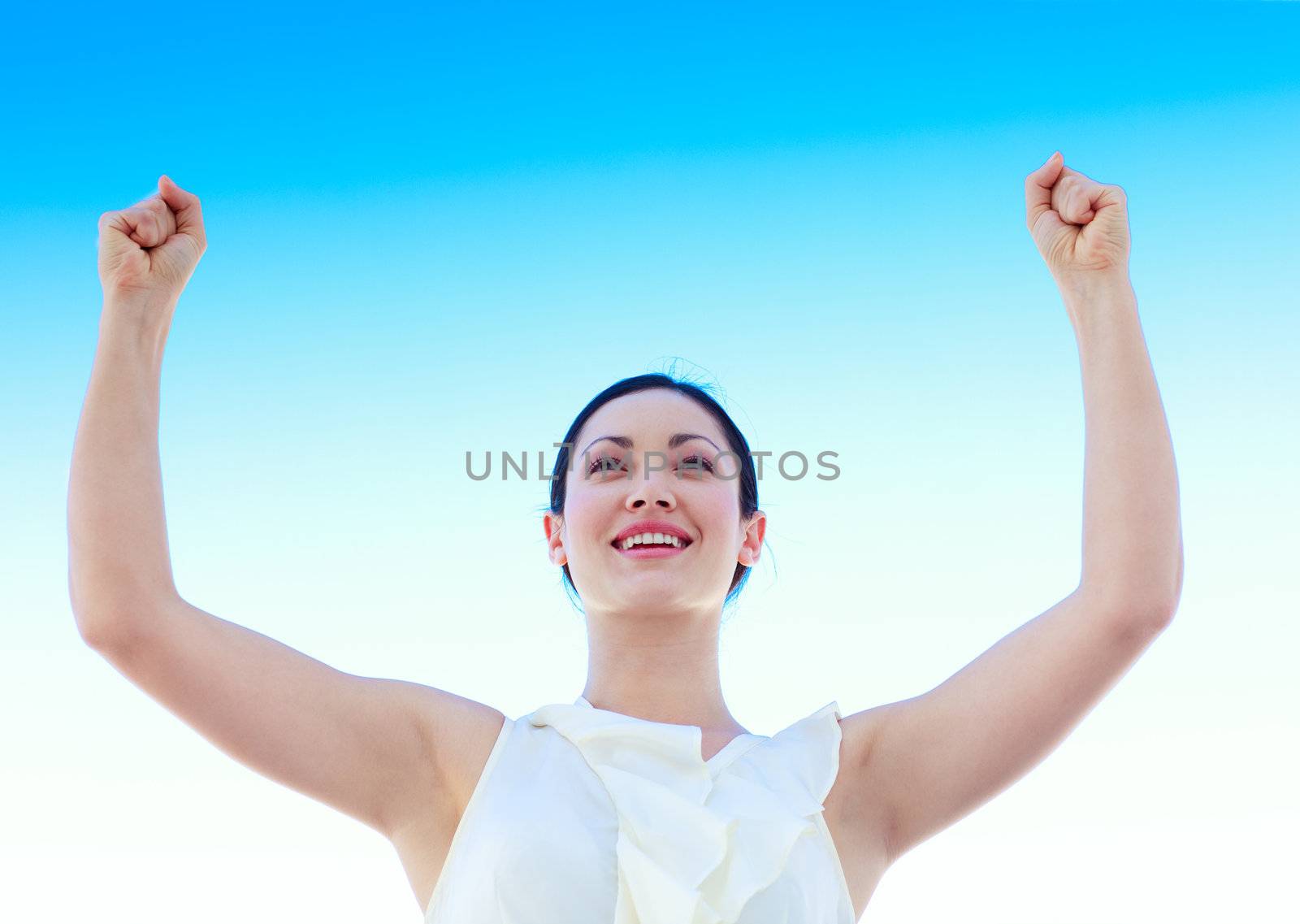 Smiling young businesswoman outdoors against blue sky