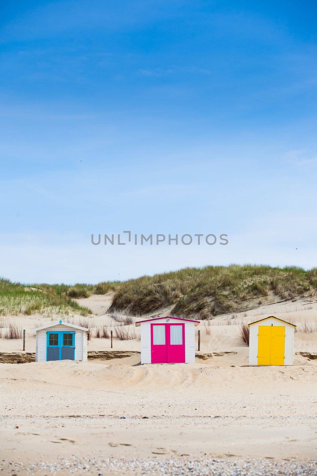 Colorfull Dutch houses on the beach with blue sky. Texel, Holland