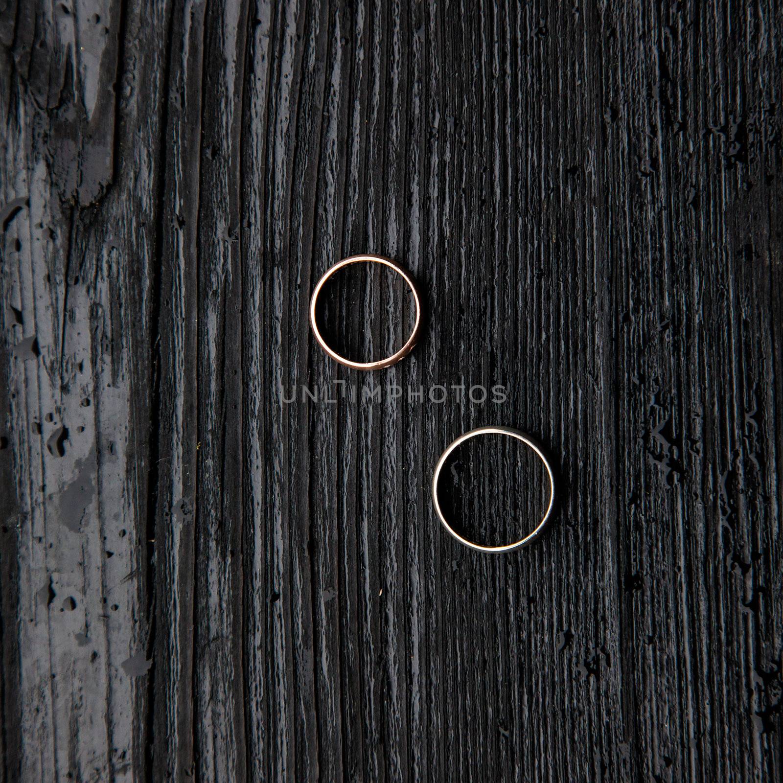 Wedding rings on a dark wooden background.