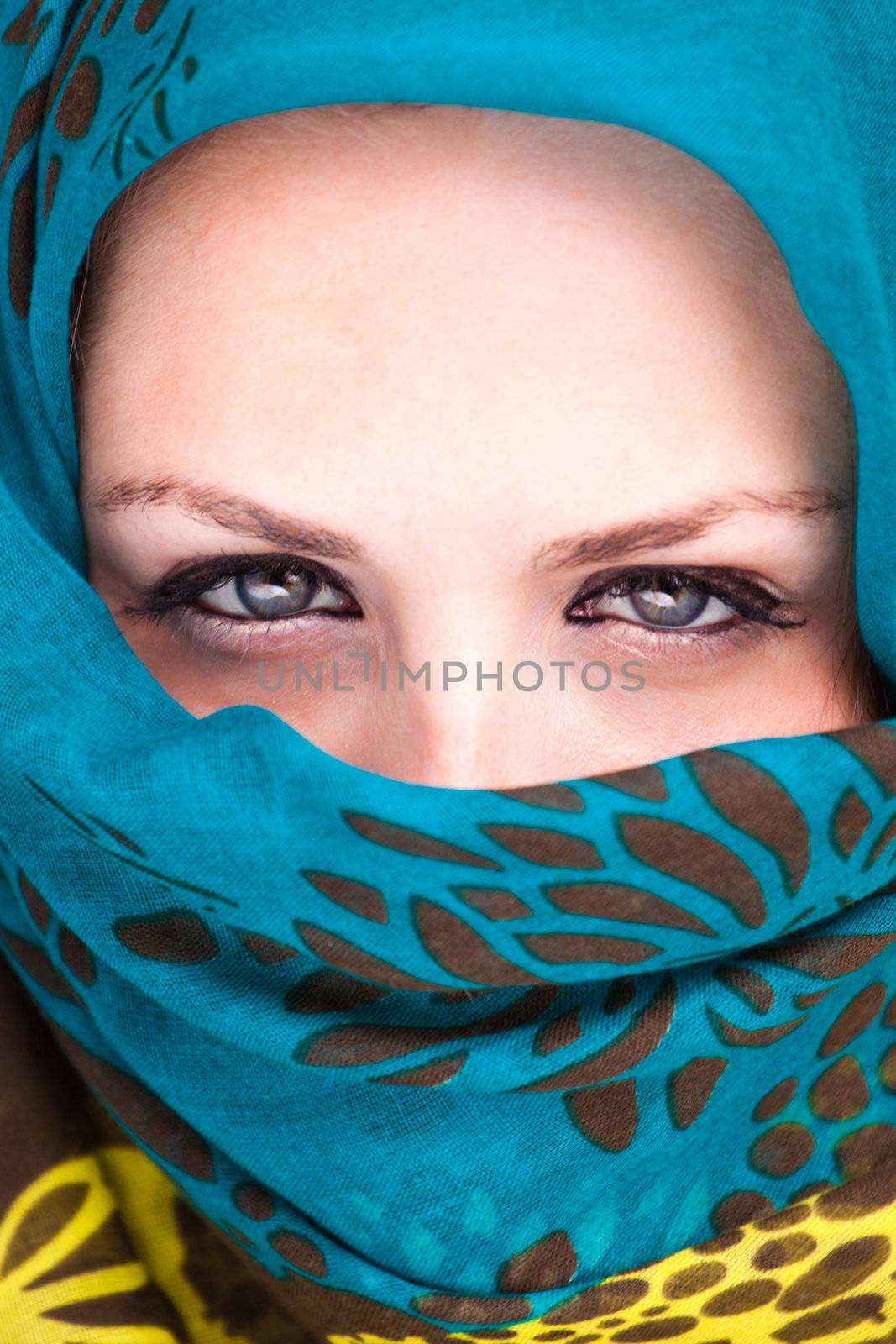 Beautiful Arab woman wearing blue scarf, stylish female close up face portrait, serious expression, stunning sensual beauty.