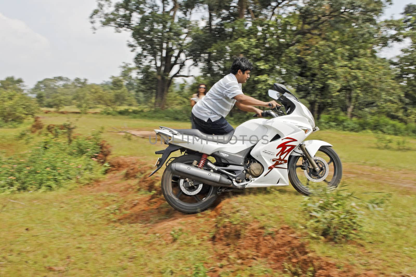 Pachmarchi, Madhya Pradesh, India - September 30, 2012: Bike and rider trials competition. One of the heats was to run 50 meters to your bike and push up a ledge to a designated spot, with or without team mates help watched by judges