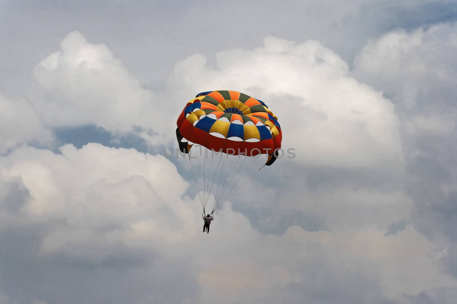 Generic landscape of a pair of male para gliders sailing amongst blue skies and clouds. Location could have been any where but this shot is take in Pachmarhi, Madhya Pradesh, India