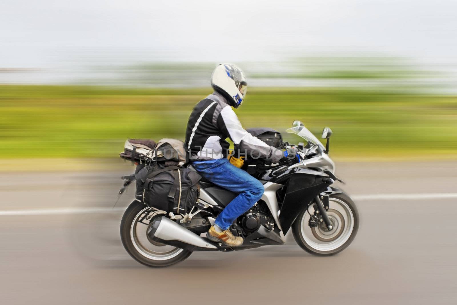 Touring motorcyclist speeding to get home from recent tour. Shot location, Maharashtra, India