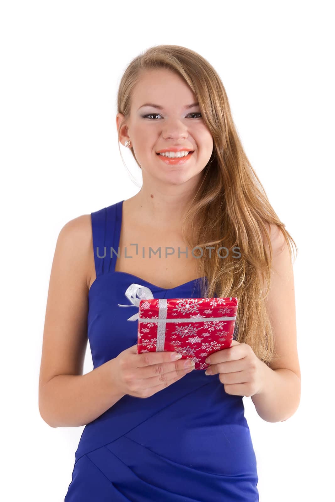 The smiling girl in a blue dress with long hair with a Christmas gift in hands