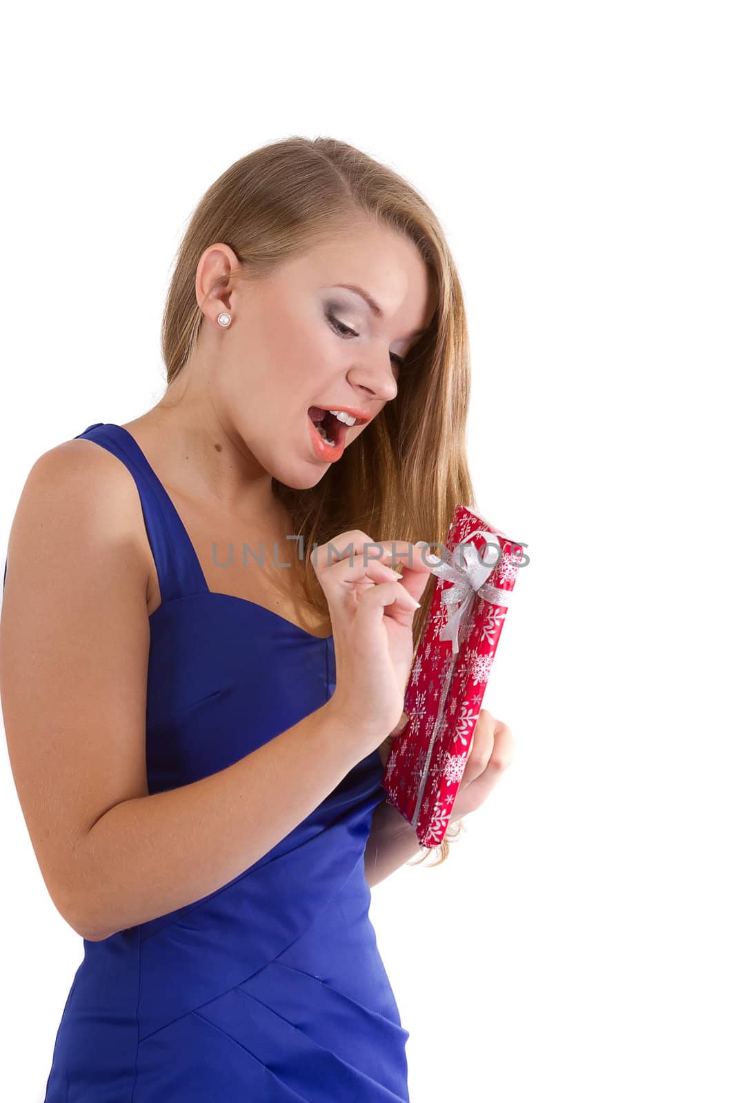 girl in a blue dress with long hair happy unpacks Christmas gift