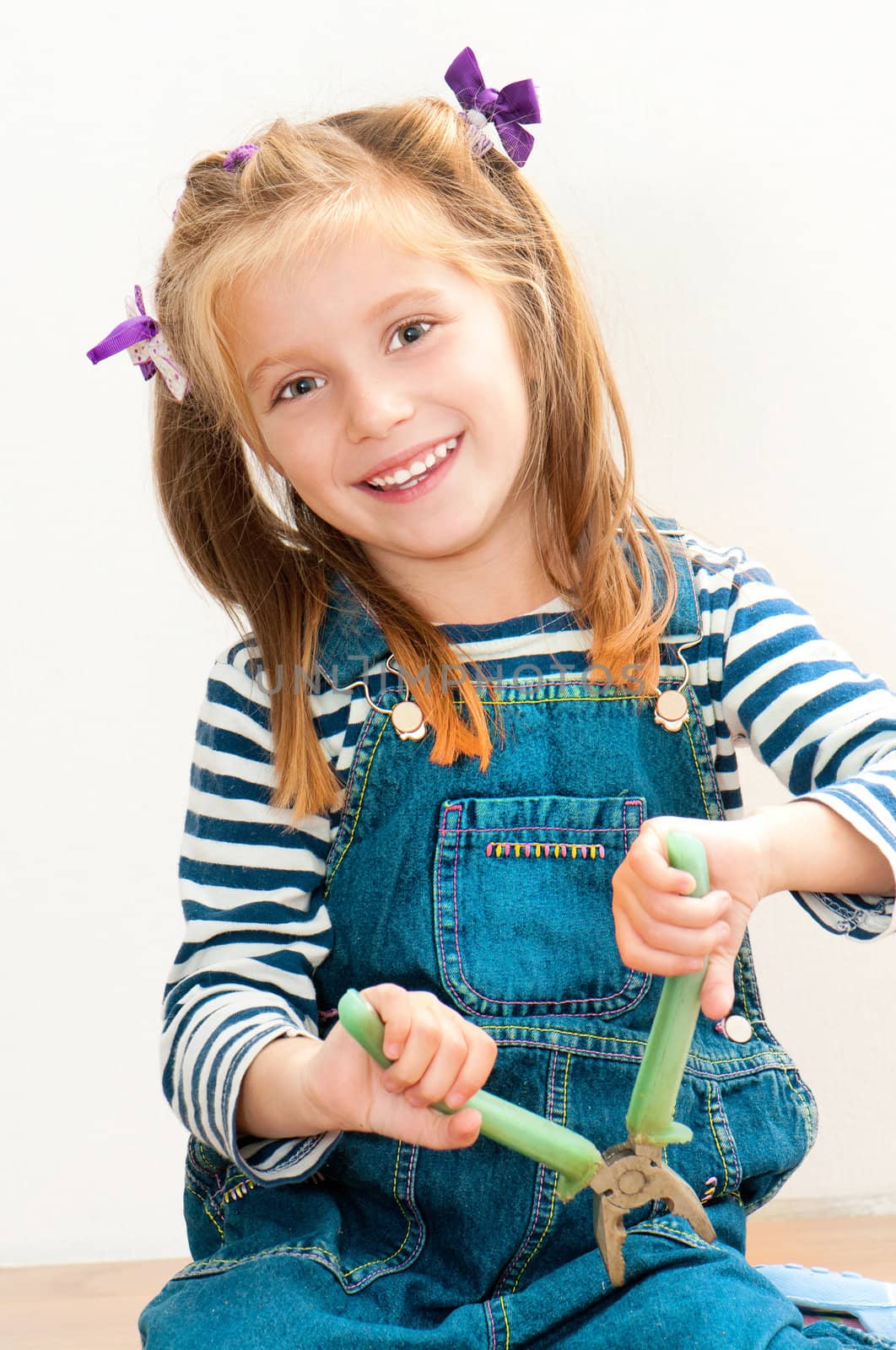 little smiling girl with old pliers