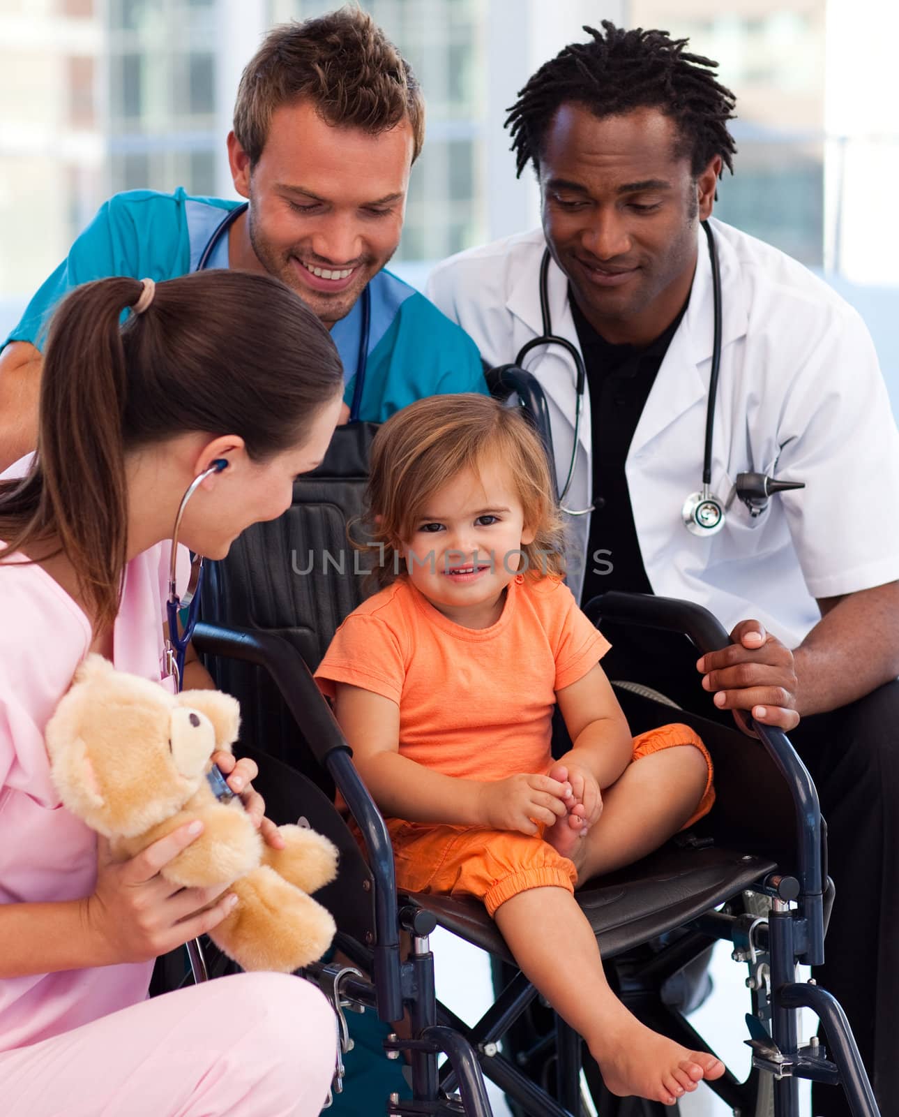 Portrait of a little patient with medical team in a wheelchair