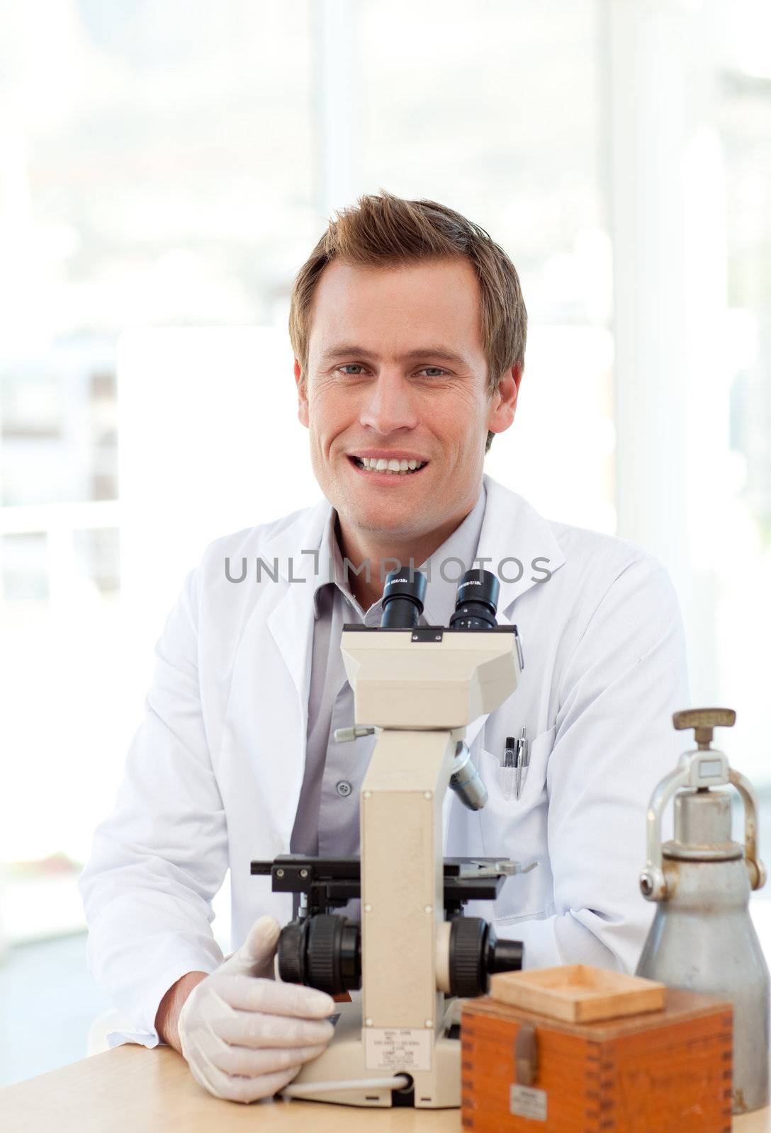 Male scientist looking through a microscope in a laboratory