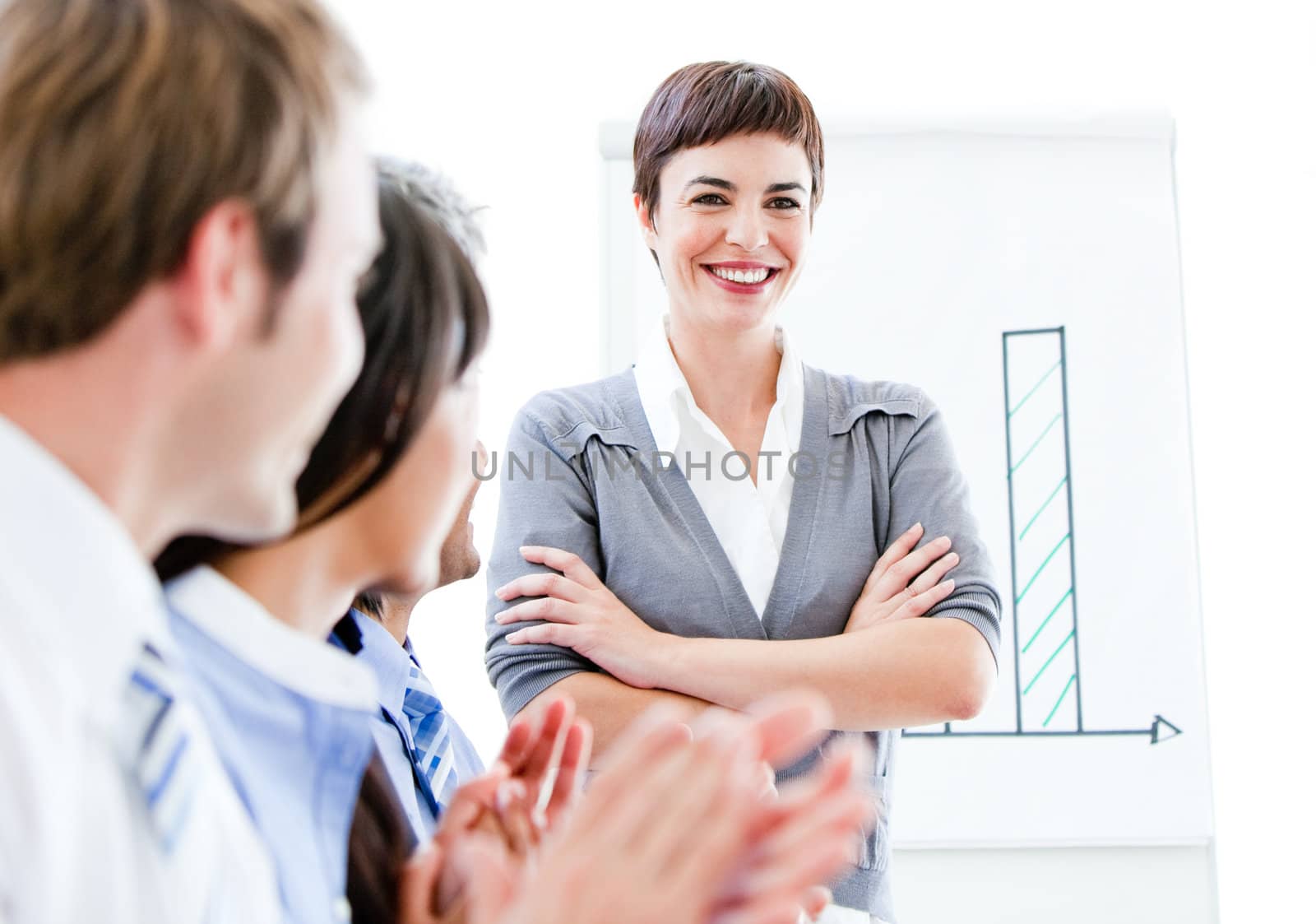 Portrait of a smiling businesswoman talking at her colleague during a meeting in the office 