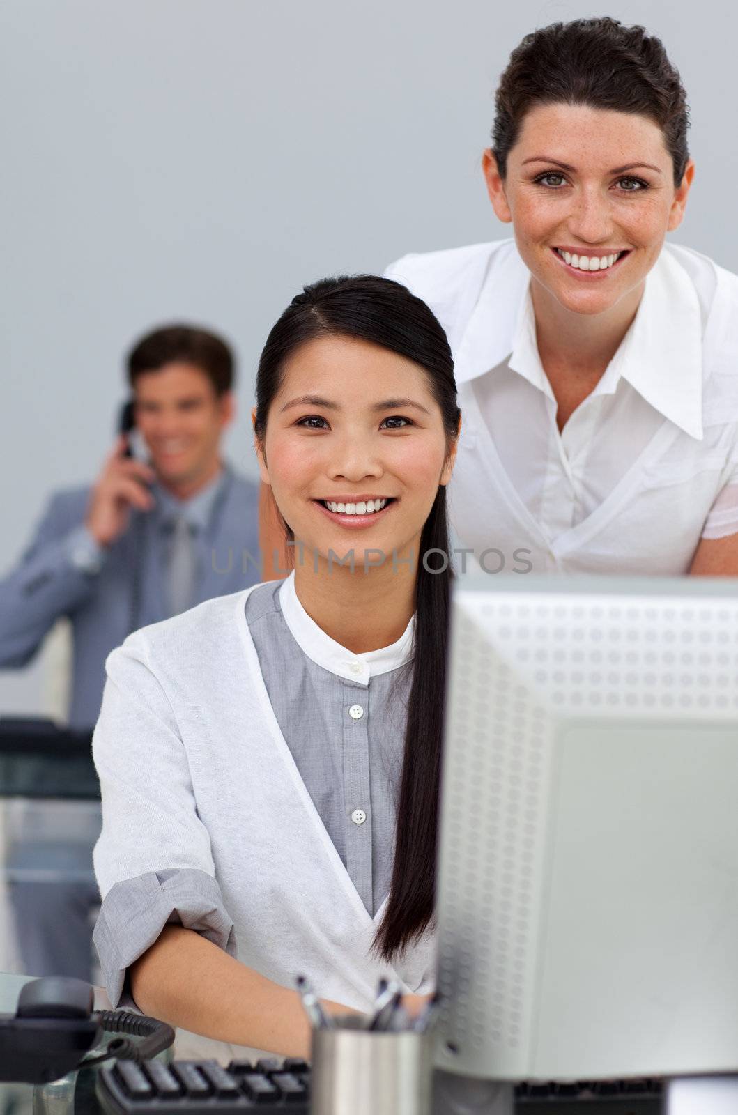 Charming businesswoman helping her colleague at a computer  by Wavebreakmedia