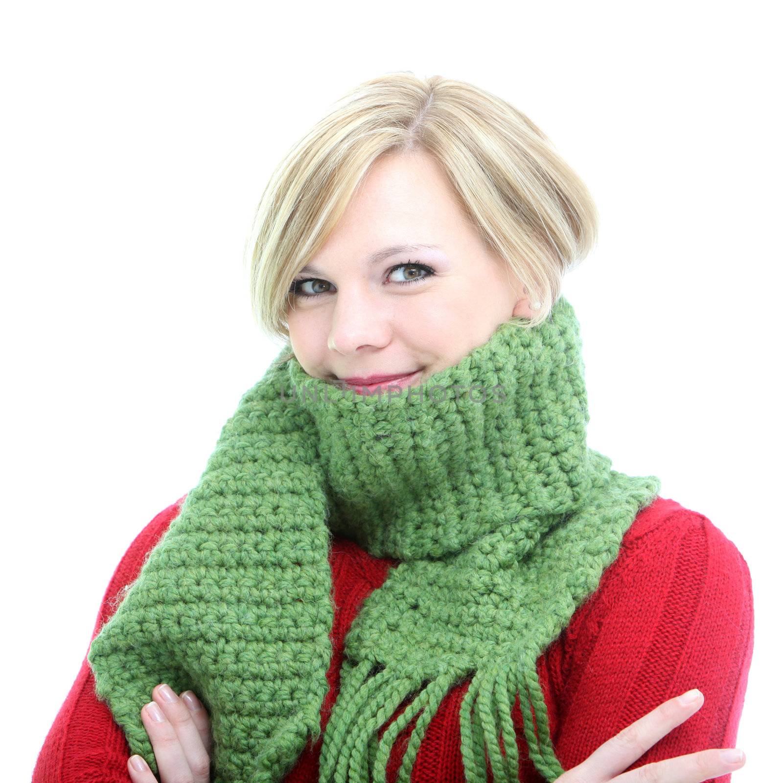 Smiling blonde woman wrapped up warmly in a green wool winter scarf isolated on white