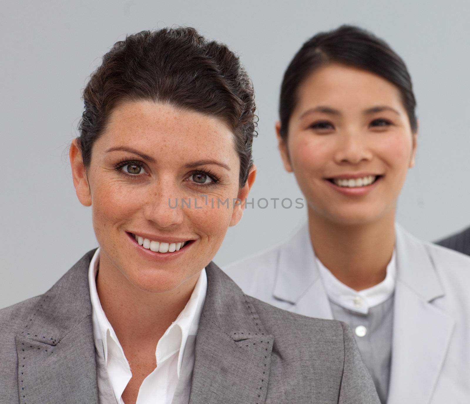 Attractive Business people standing in a line smiling at the camera