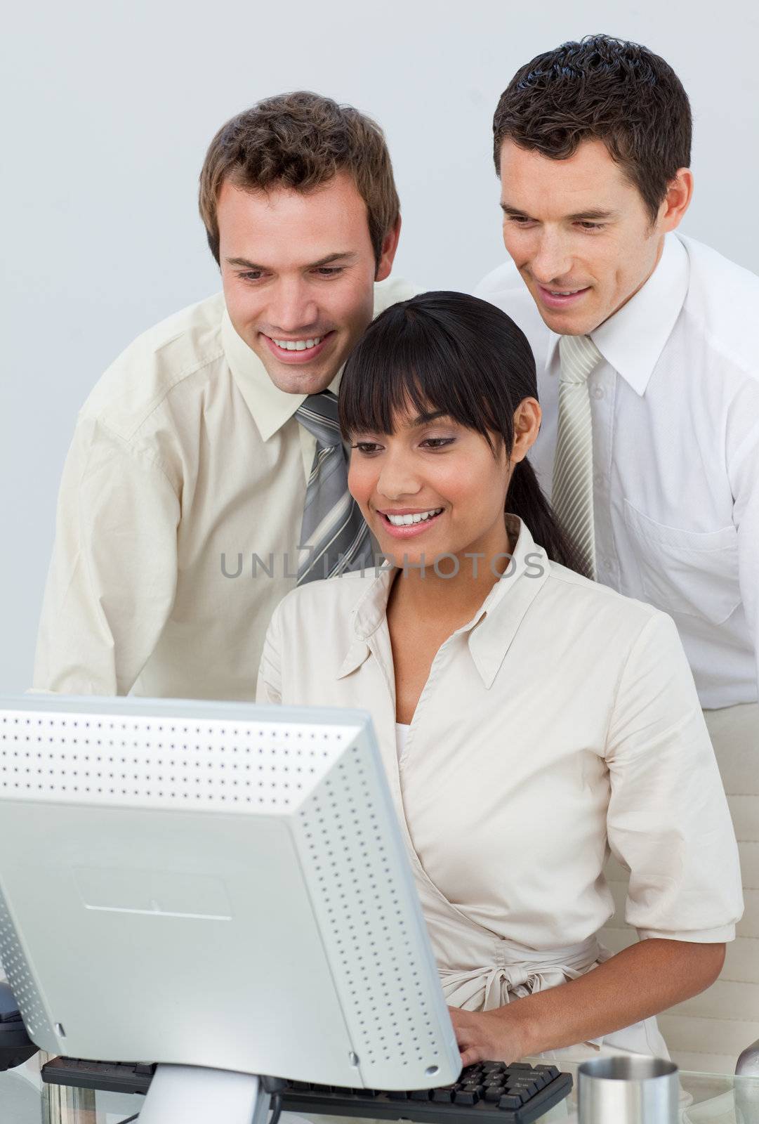 Businessmen and ethnic businesswoman working with a computer in an office