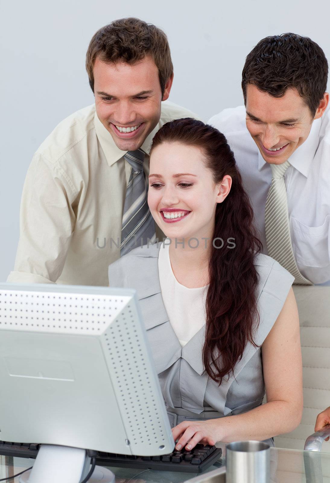 Businessmen helping her colleague with a computer by Wavebreakmedia