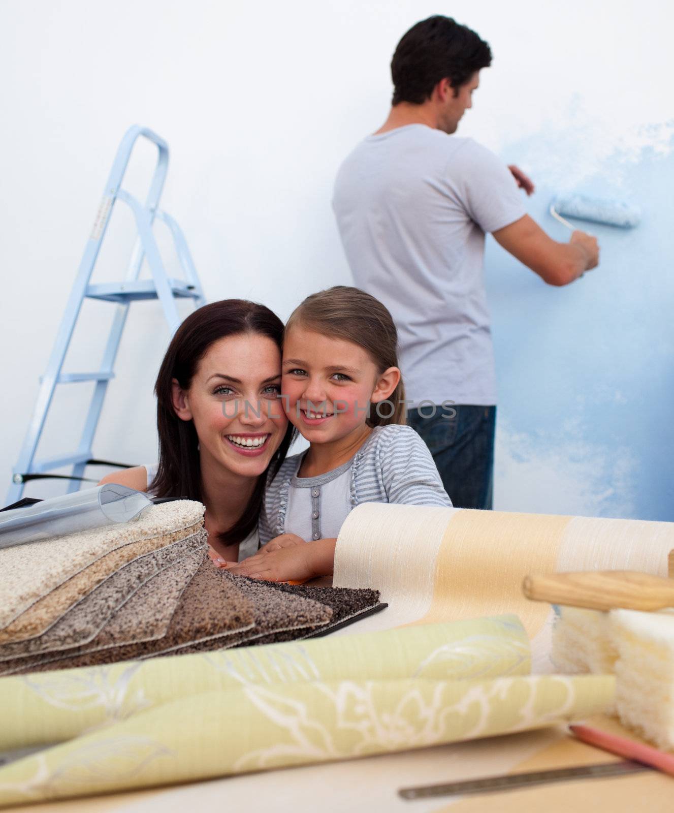 Smiling family renovating their new home by Wavebreakmedia