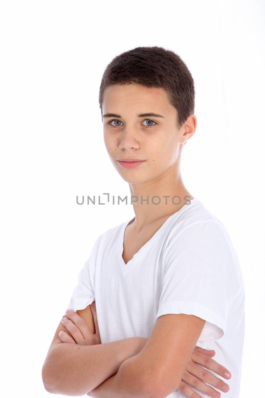 Serious teenage boy standing looking at the camera with folded arms isolated on white