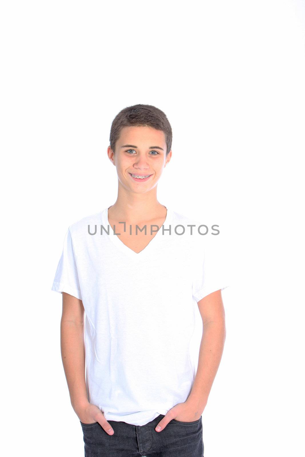 Smiling confident teenage boy dressed casually in jeans standing with his hands in his pockets isolated on white Smiling confident l teenage boy dressed casually in jeans standing with his hands in his pockets isolated on white