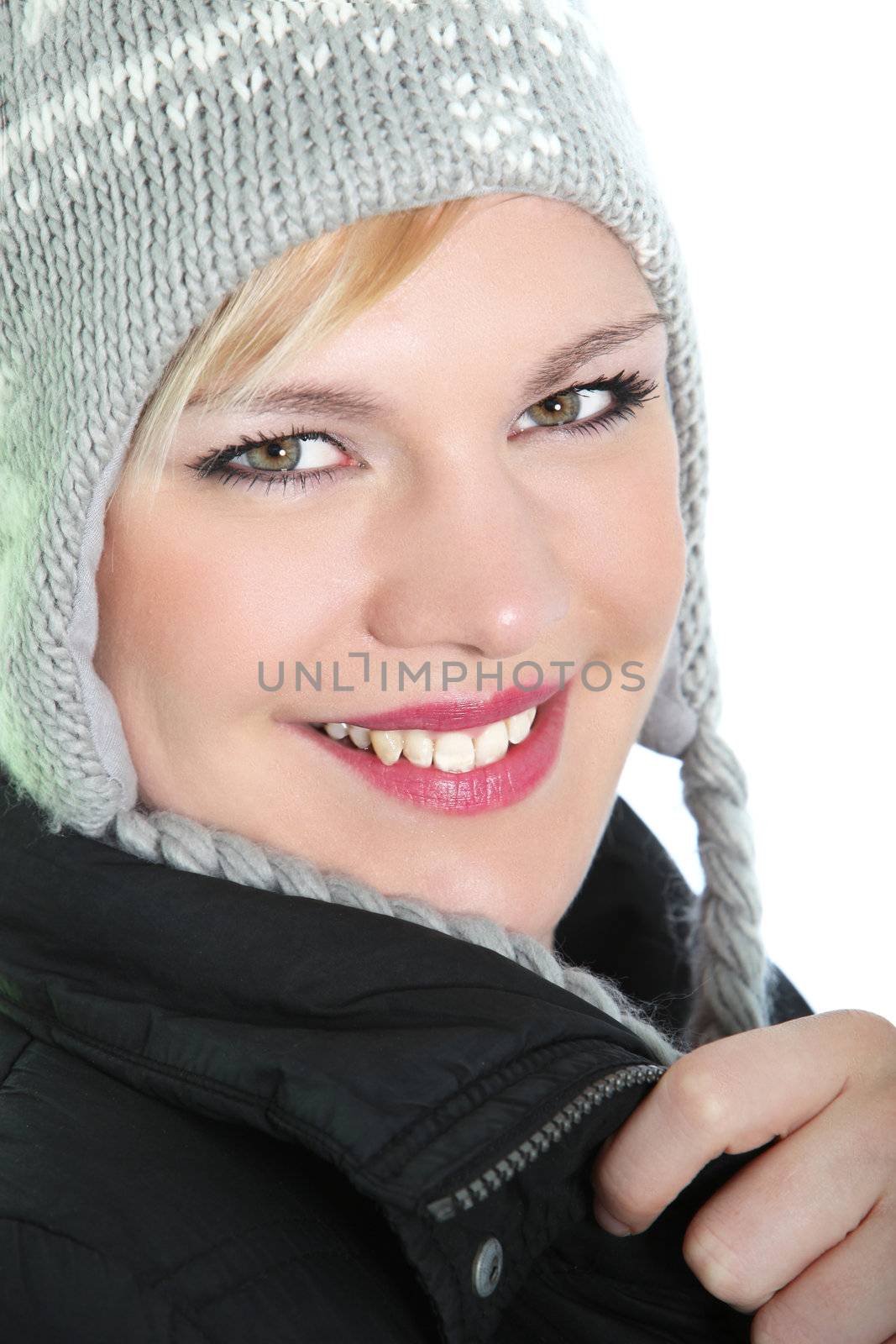 Closeup portrait of a lovely blonde girl with a beautiful smile wearing a knitted warm winter hat Closeup portrait of a lovely blonde girl with a beautiful smile wearing a knitted warm winter hat