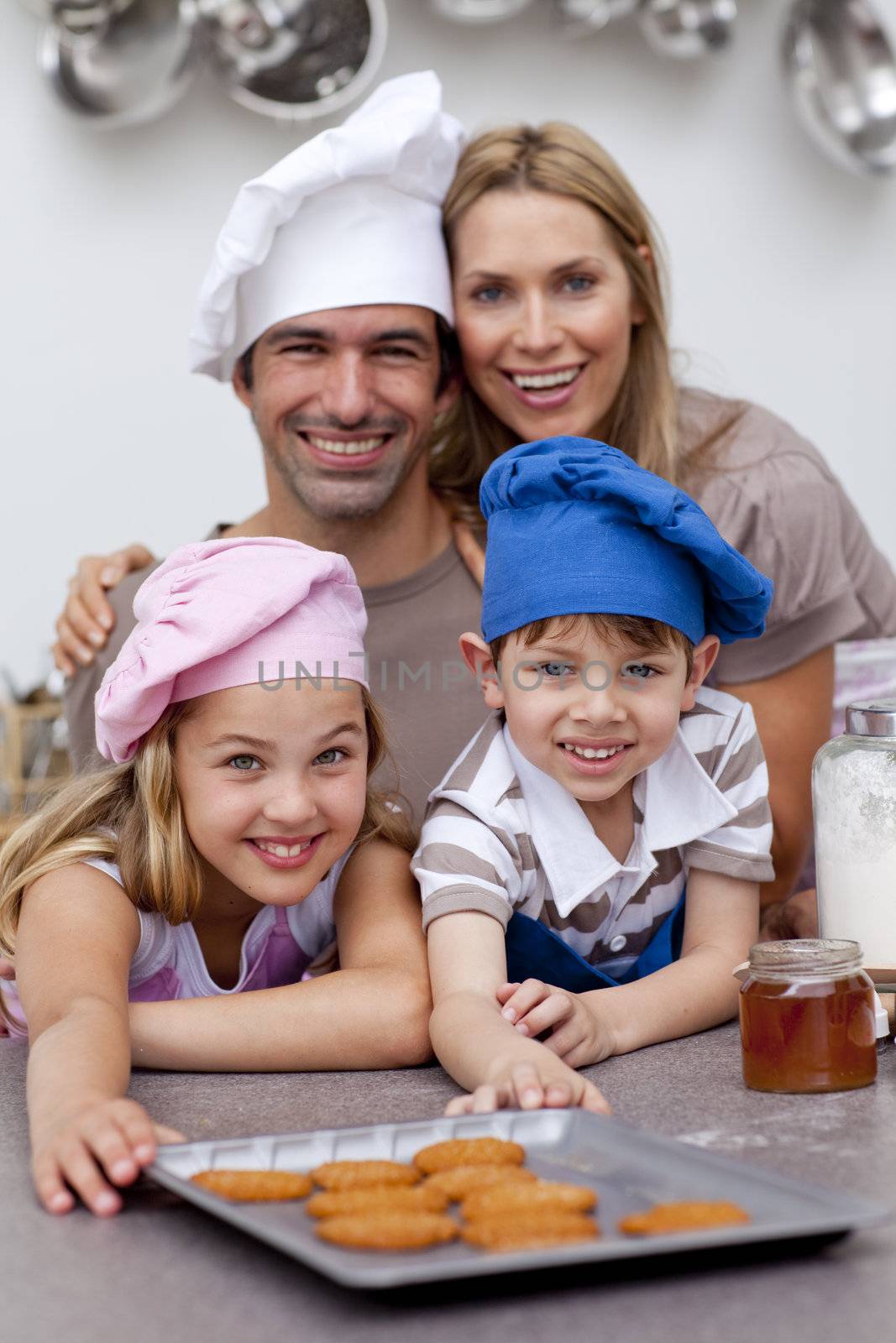 Happy children and parents eating biscuits in the kitchen