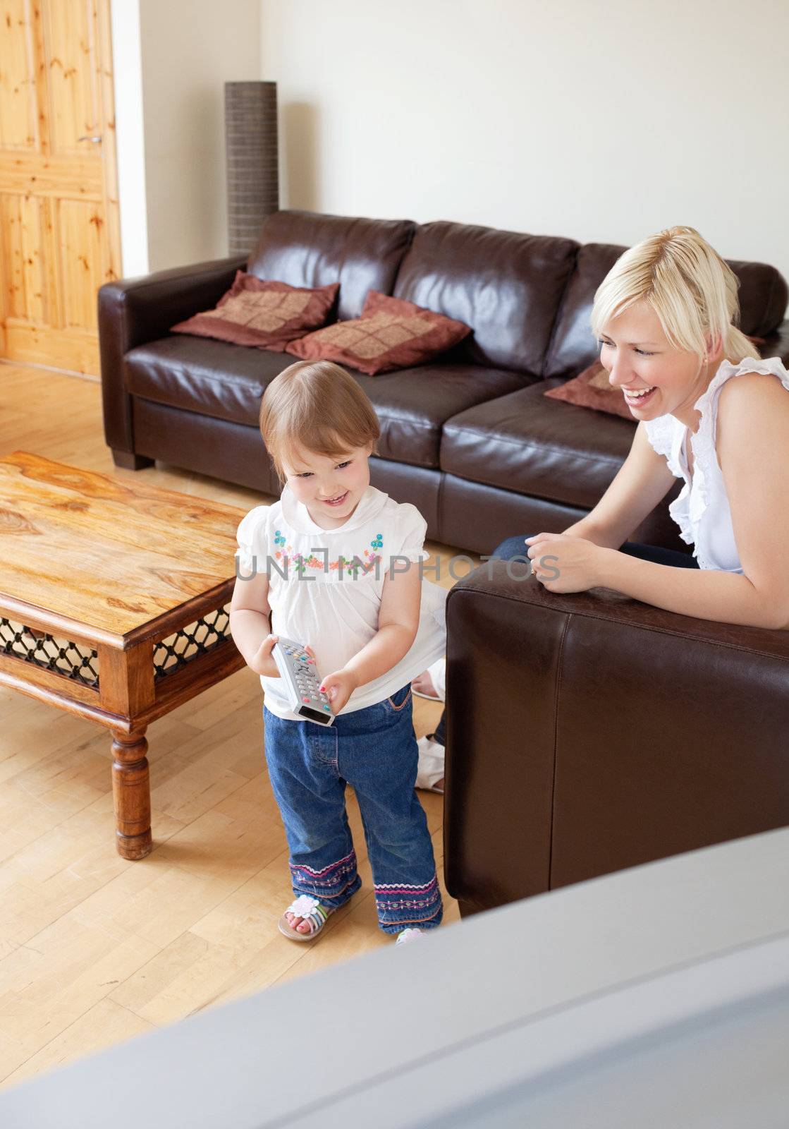 Laughing family in the living room child holding a remote
