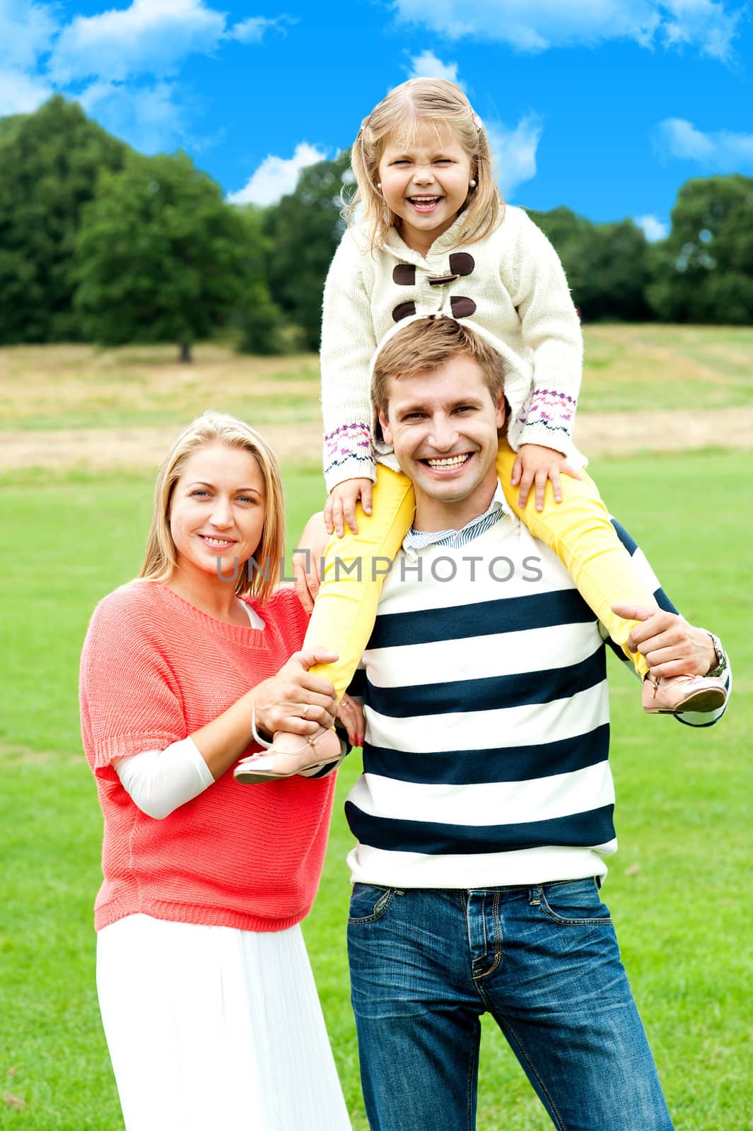 Pretty daughter enjoying day out with parents by stockyimages