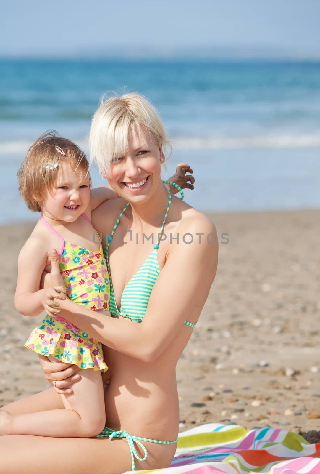 A smiling mother with her daughter at the beach 