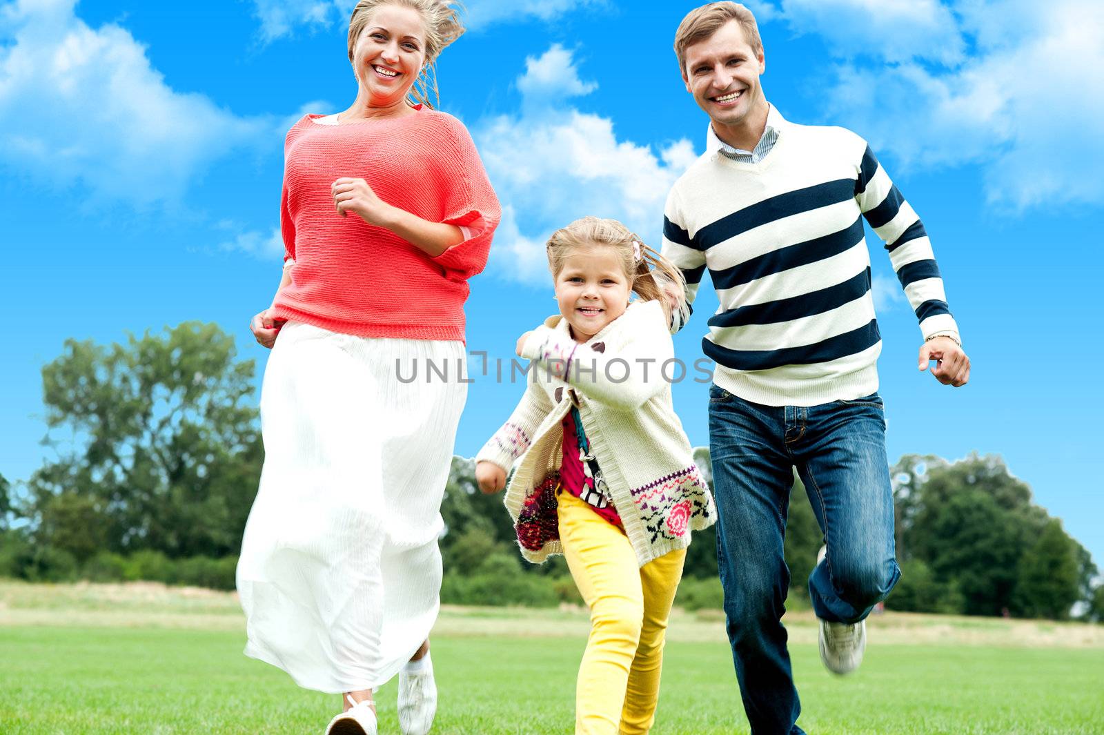 Active young parents running to catch their daughter. Fun loving family