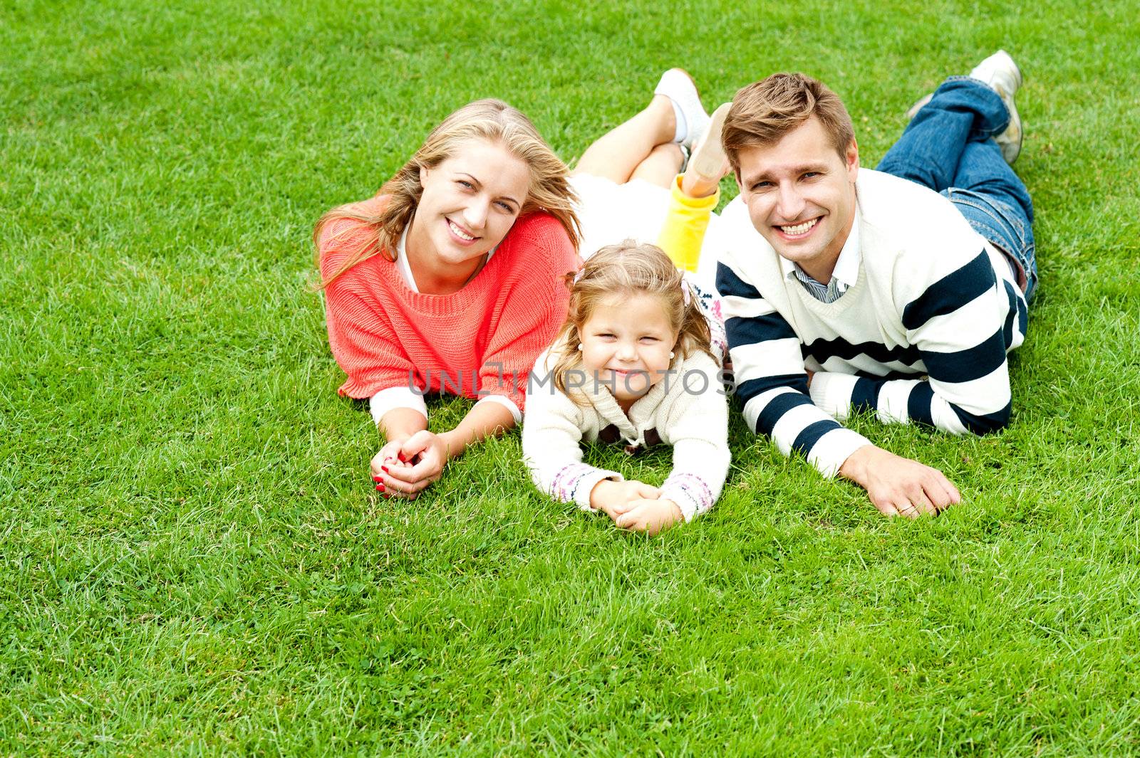 Laughing family of three having fun together on a sunny summer day