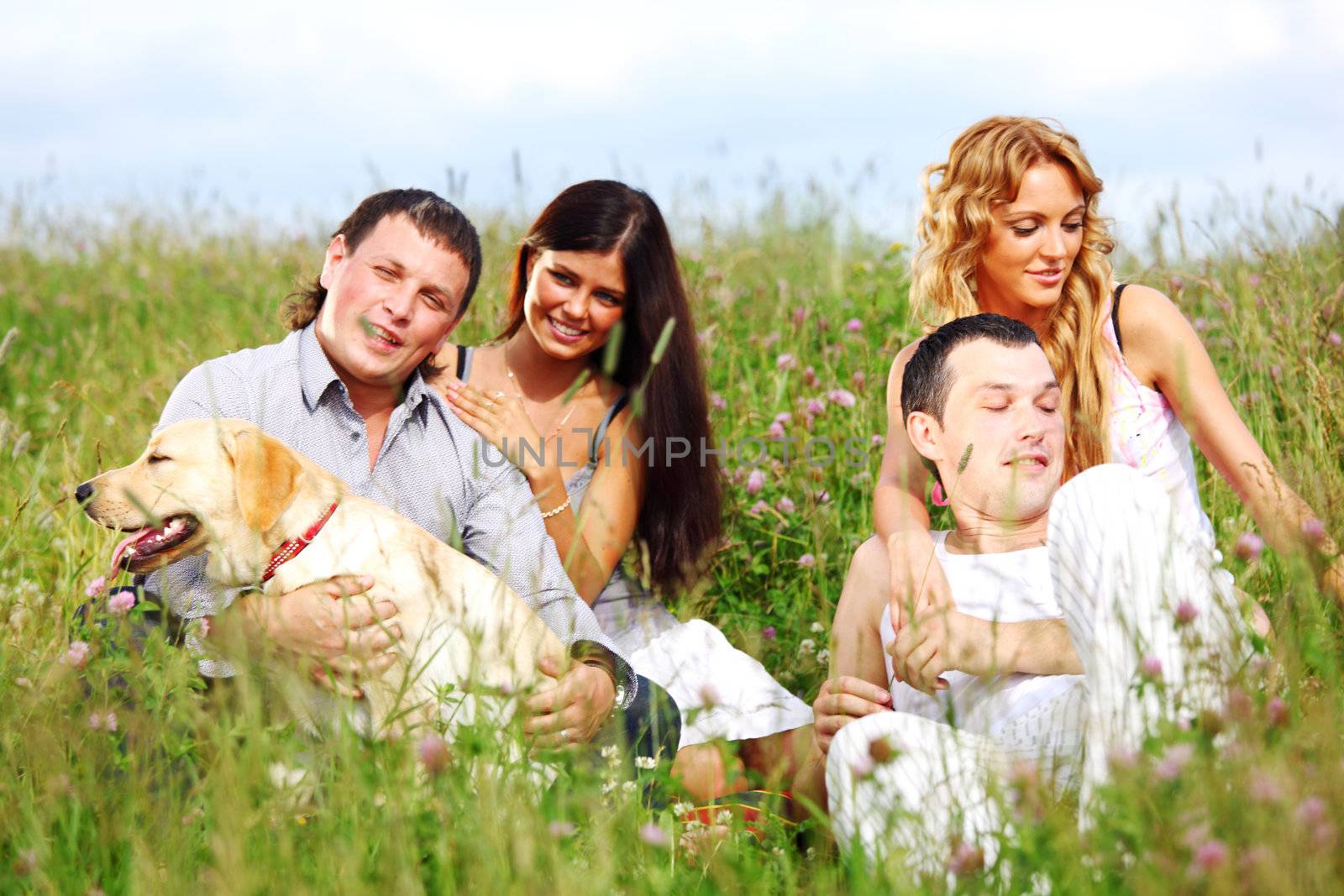 friends and dog in green grass field