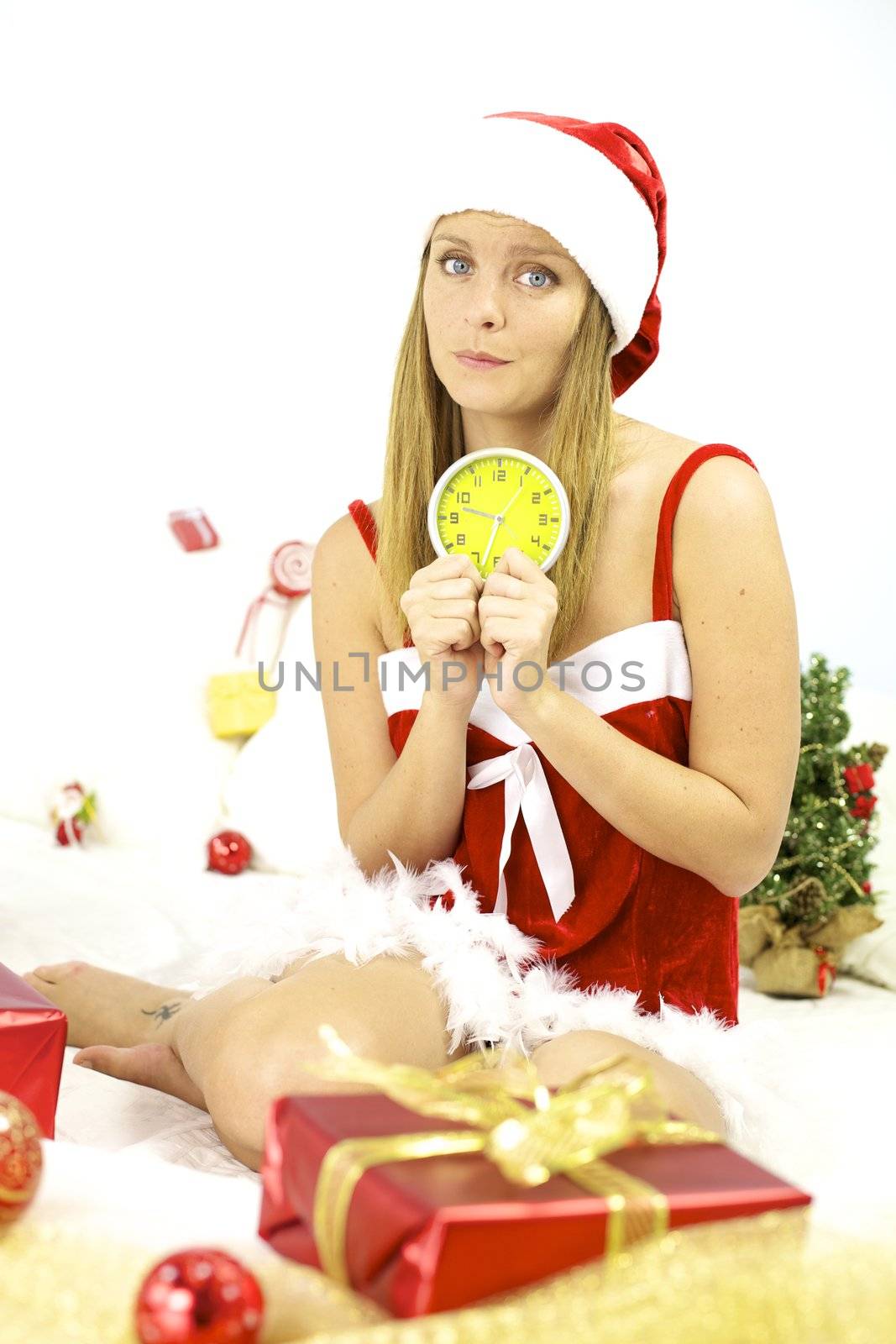 Sad Santa Claus with alarm clock not ready for Christmas night