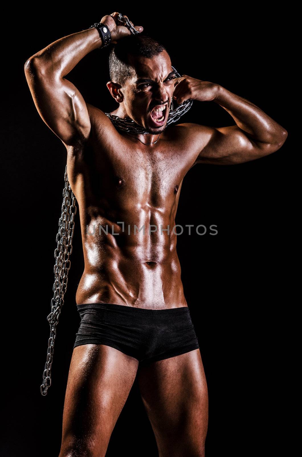 Bodybuilder with chains in dark by Elnur