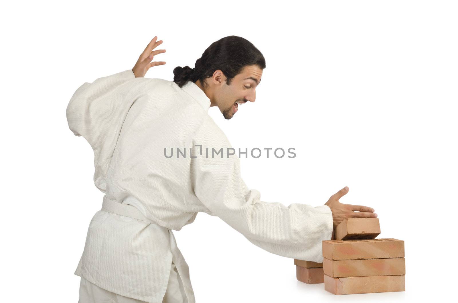 Karate man breaking bricks on white by Elnur