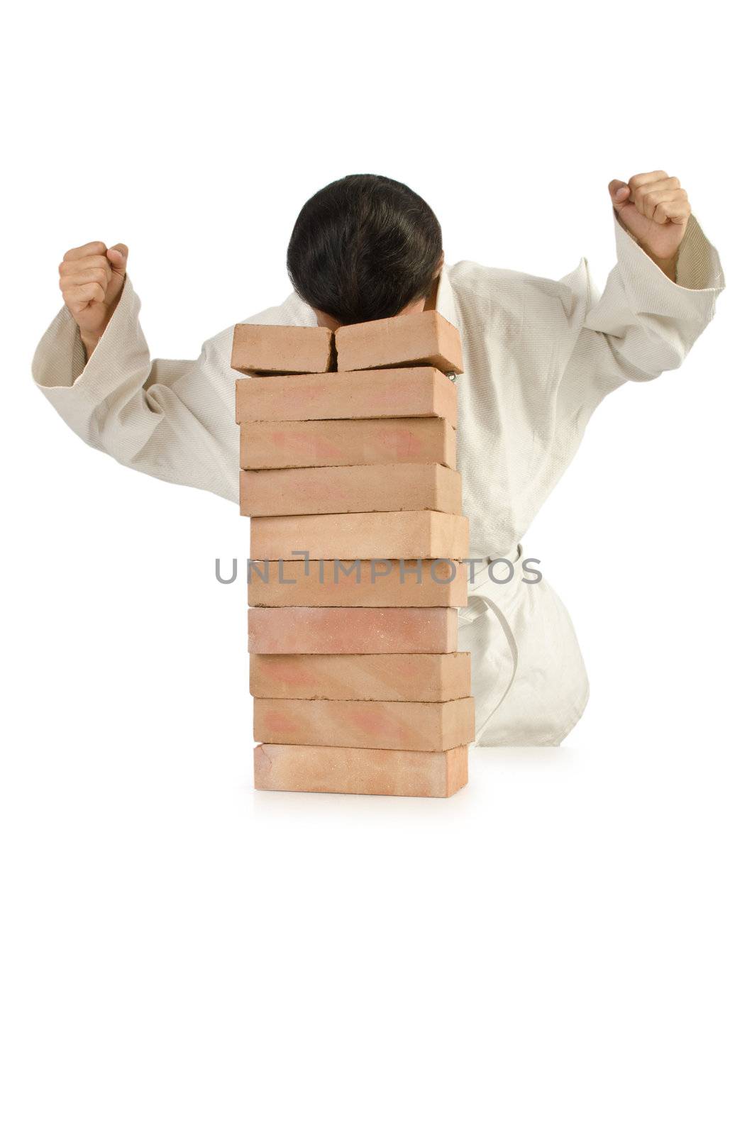 Karate man breaking bricks on white