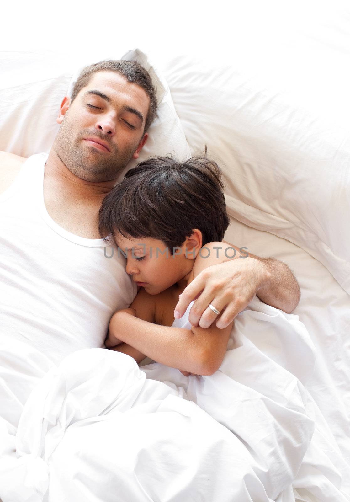 Young family sleeping and lying on a white bed