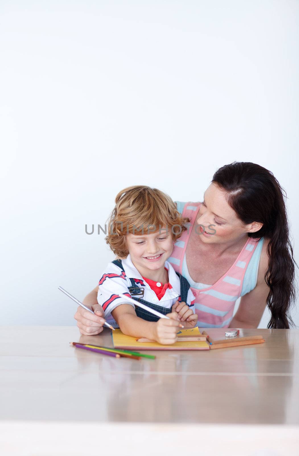 Loving mother help his son to draw a picture against white background