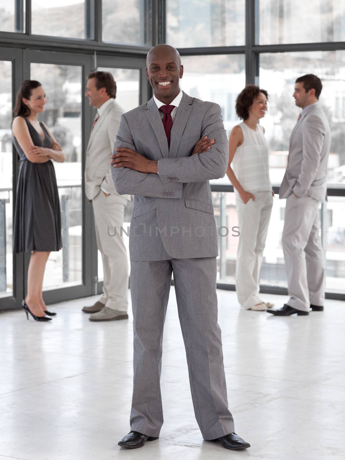 portrait of an afro manager leading his team in a office