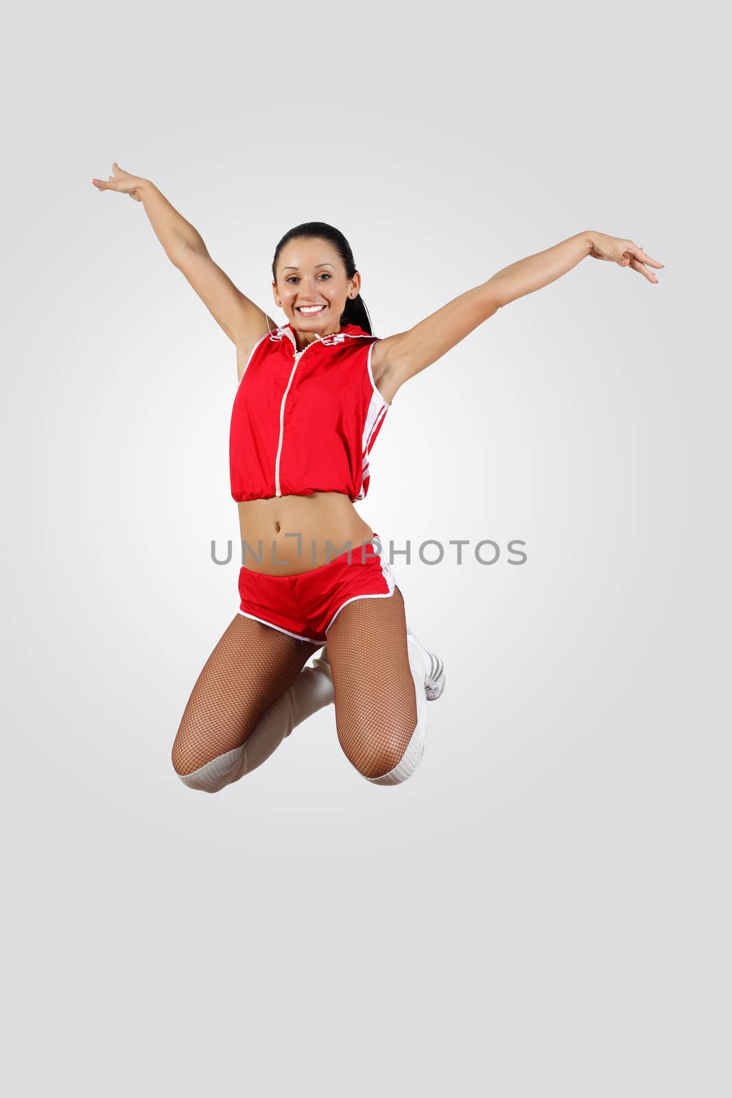 Young female dancer jumping against white background