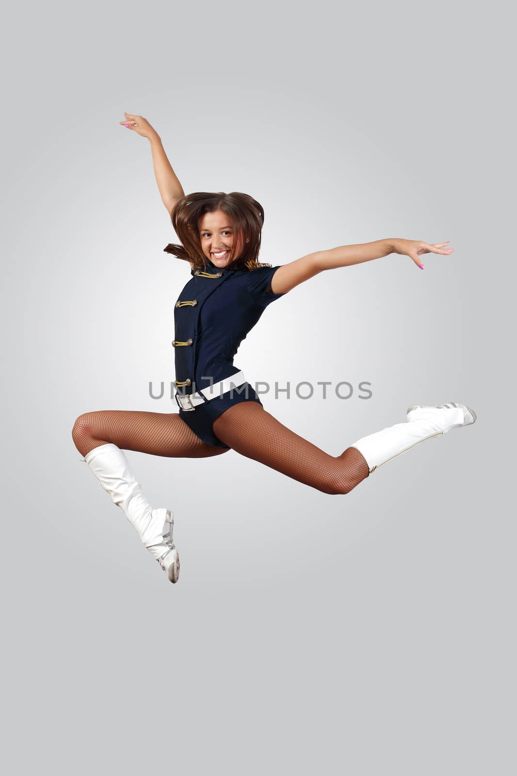 Young female dancer jumping against white background